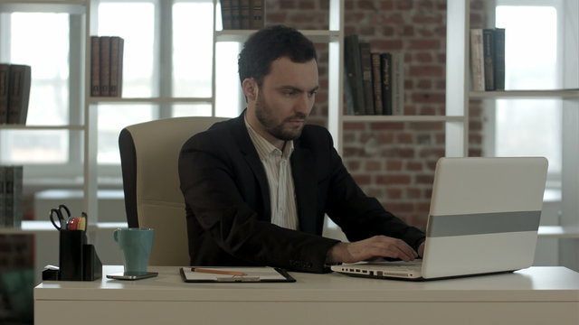 Panicking businessman in horror looking at the laptop screen 