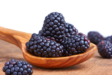 Bowl of yogurt and fresh Blackberries on a wooden table