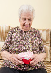 a happy senior woman opening a gift box