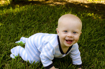 Smiling blond baby boy crawling
