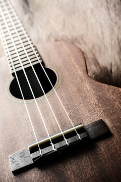 Close up of ukulele on old wood background with soft light
