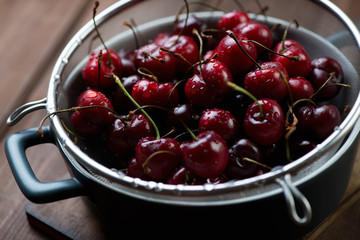 Close-up of fresh sweet cherries in a colander, selective focus