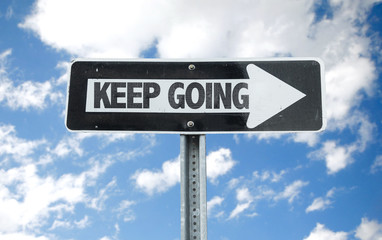 Keep Going direction sign with sky background