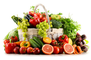 Organic vegetables and fruits in wicker basket isolated on white