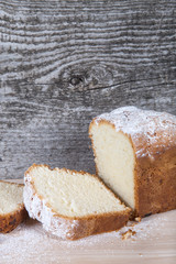 Cake with raisin and sugar powder on the wooden table. Selective
