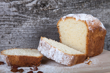 Cake with raisin and sugar powder on the wooden table. Selective
