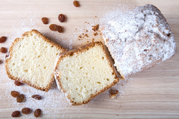 Cake with raisin and sugar powder on the wooden table. Selective