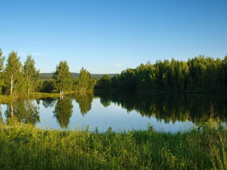 Fototapeta na wymiar Silent lake near green forest