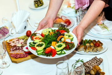 Obraz na płótnie Canvas Plate with sliced vegetables in female hands