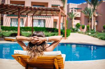 woman lying on a lounger by the pool at the hotel
