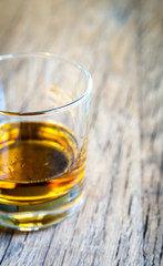 Glass of rum on the wooden background