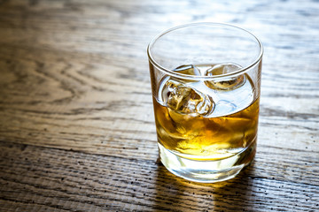 Glass of rum on the wooden background