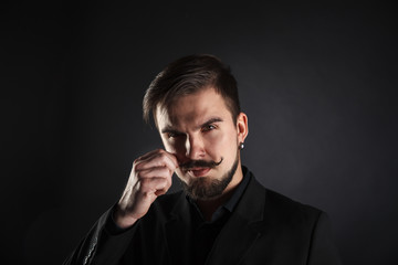 handsome brutal guy with beard on dark background