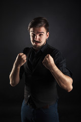 handsome brutal guy with beard on dark background