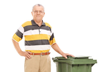 Senior standing by a trash can isolated on white