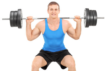 Strong man exercising with a barbell isolated on white