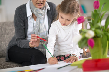 girl doing  at homework  with the help of grandmother