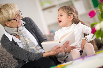 little girl with grandma reading interested book
