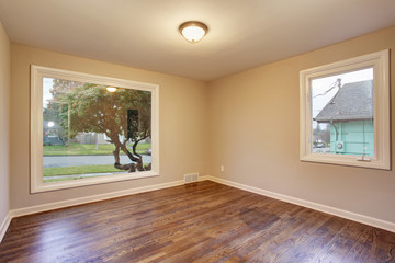 Hardwood bedroom with large drop window.