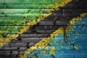 painted tanzanian flag on a wooden texture