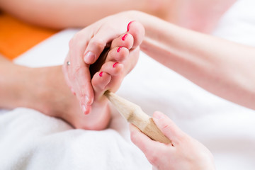 Women at reflexology having foot massaged