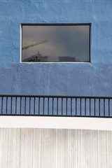 Blue and wall with window showing reflection
