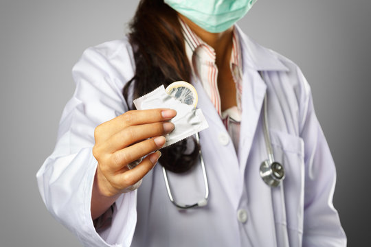 Female doctor holding condom