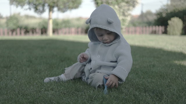 cute baby boy wearing onesie smiling and running in the garden