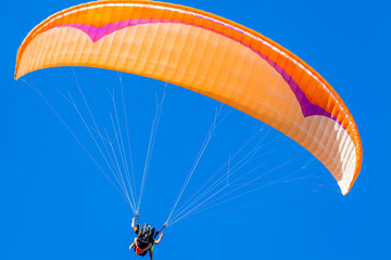 vol en parapente biplace sur fond de ciel bleu outremer
