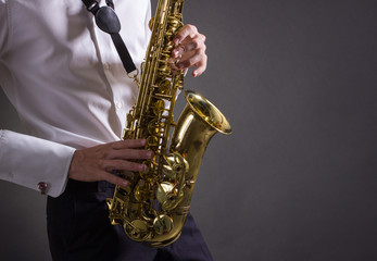 Fototapeta na wymiar A man plays the saxophone close up.