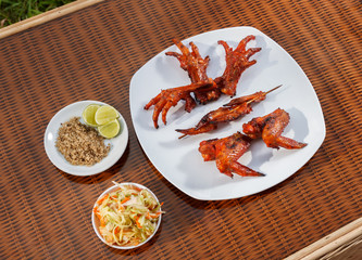 Grilled chicken on white plate with parsley, salad and beer outdoors