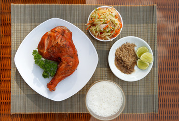 Grilled chicken on white plate with parsley, salad and beer outdoors