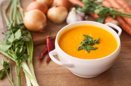 carrot soup with vegetables on wood table