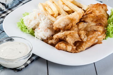 Fish and chips with tartar sauce on a plate