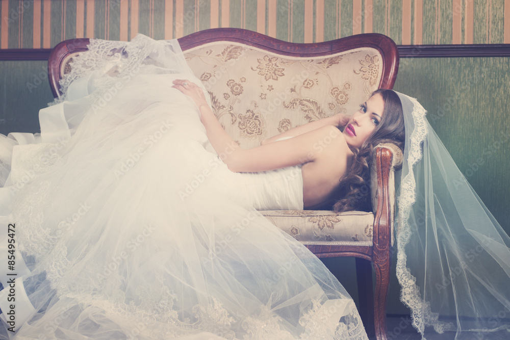 Wall mural beautiful bride on a retro couch