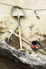 pick, shovel and  protective ear muffs of construction workers