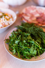 green fresh bunch of parsley and dill lying on the plate for decoration of dishes