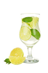 Lime into glass of water isolated on white