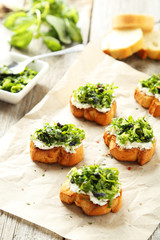 Tasty fresh bruschetta on parchment on grey wooden background