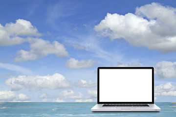 Laptop computer on wooden floor with sky  background. White screen