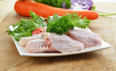 Raw chicken legs on wooden