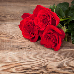 Beautiful red roses on the old board