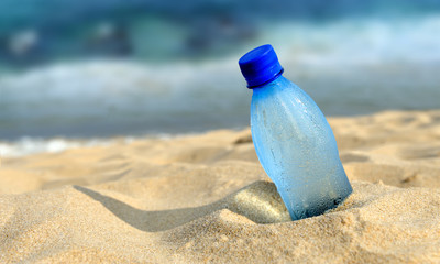 Fototapeta na wymiar Bottle of the fresh water on sand