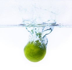 green lemon falling into the water