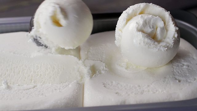 Plombir ice cream scooped out of container.