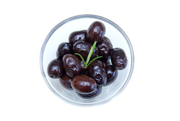 Black olives on bowl on a white background seen from above