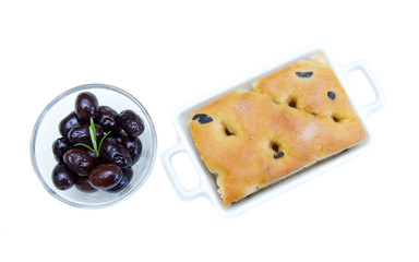 Focaccia with black olives on white background top view