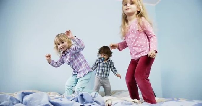 Little kids jumping on bed. Shoot on Digital Cinema Camera in slow motion - ProRes 422 codec.