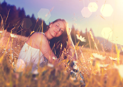 girl sitting in a meadow in sunset-enjoying the sun 3