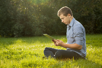 Boy with tablet pc outdoors